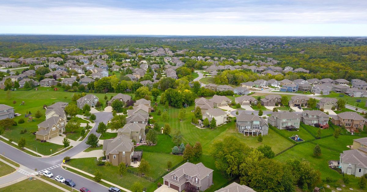 Aerial view of suburban community neighborhood houses, cul-de-sacs, and green yards
